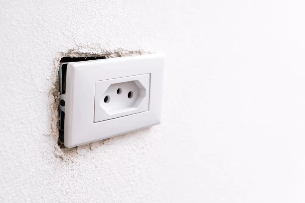tomada elétrica solta e inclinada